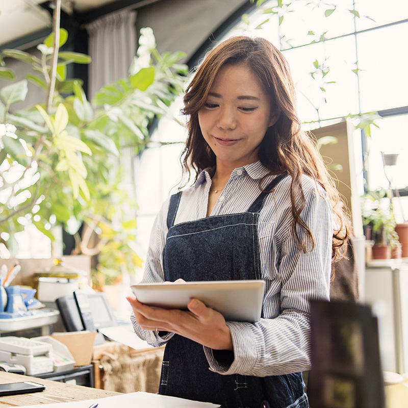 An Allercare patient working on a tablet in their plant shop